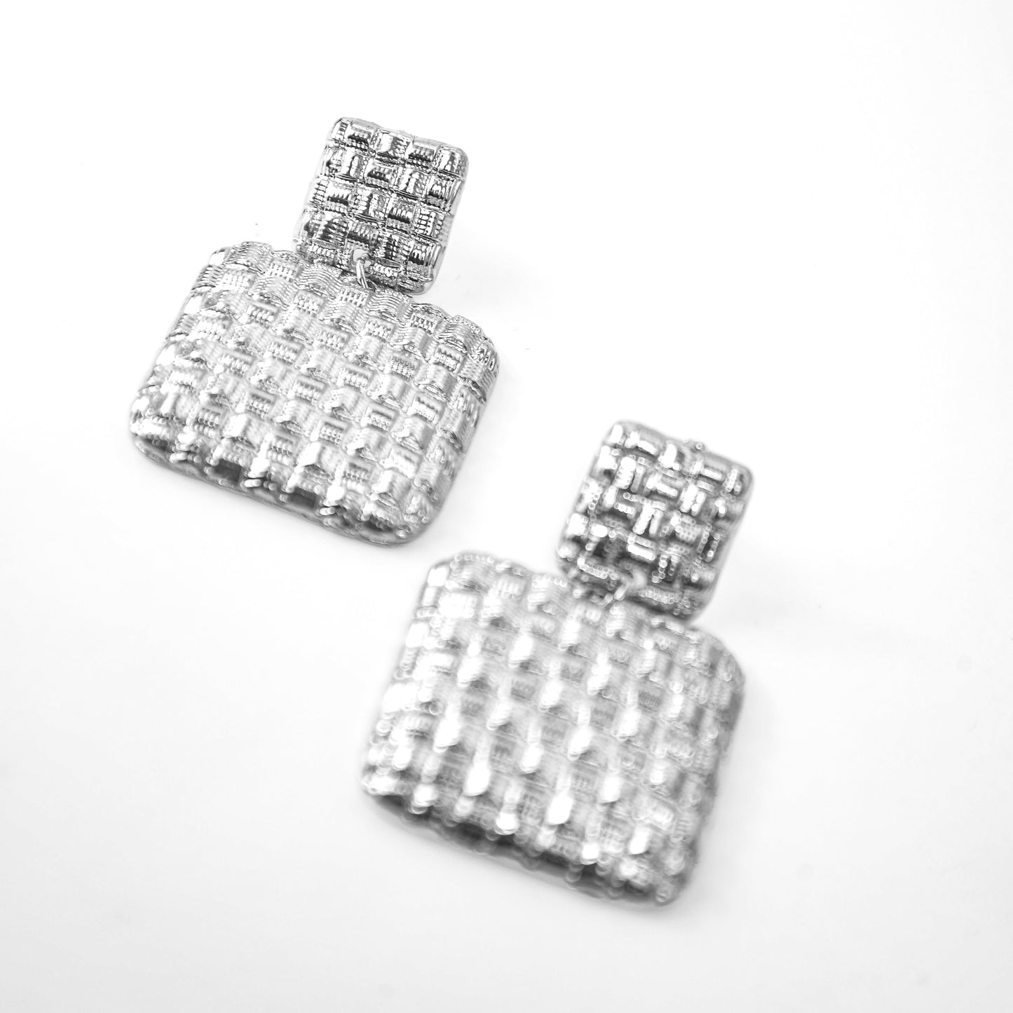 Pair of silver square earrings with clear stones on a white background