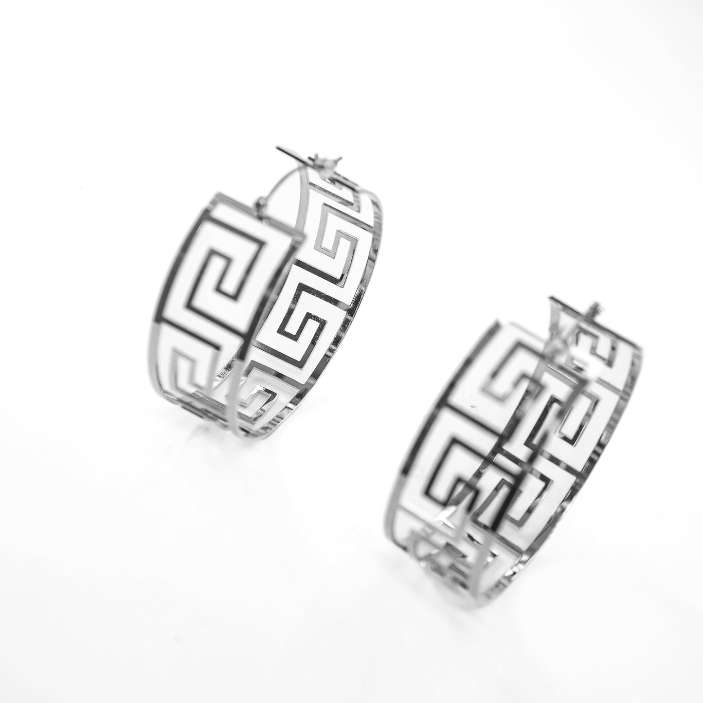Pair of silver hoop earrings with geometric design on a white background
