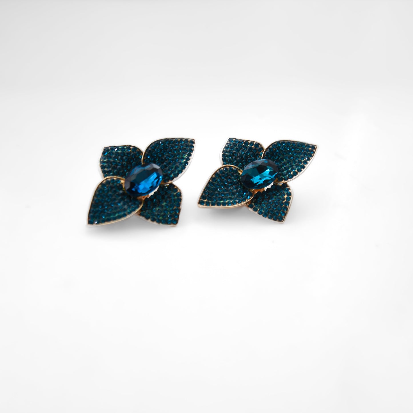 Pair of blue flower-shaped earrings on a white background
