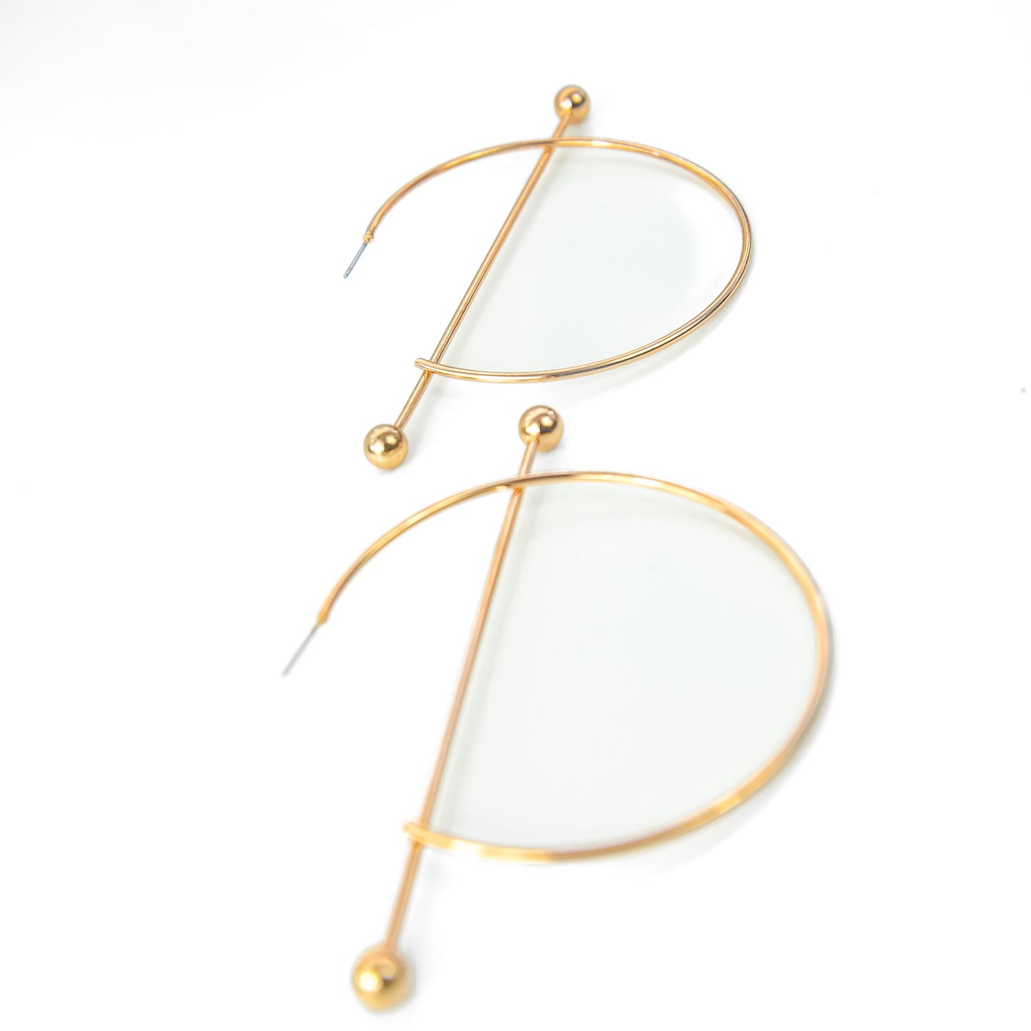 Gold-framed earrings with white stones on a white background