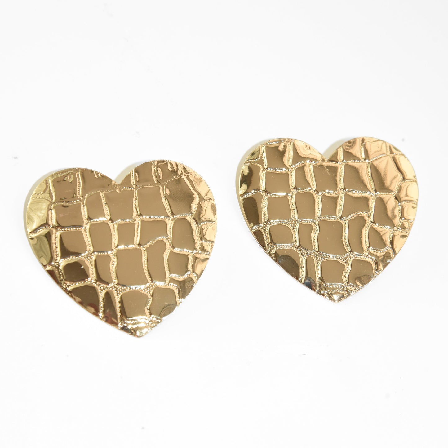 Gold heart-shaped earrings on a white background