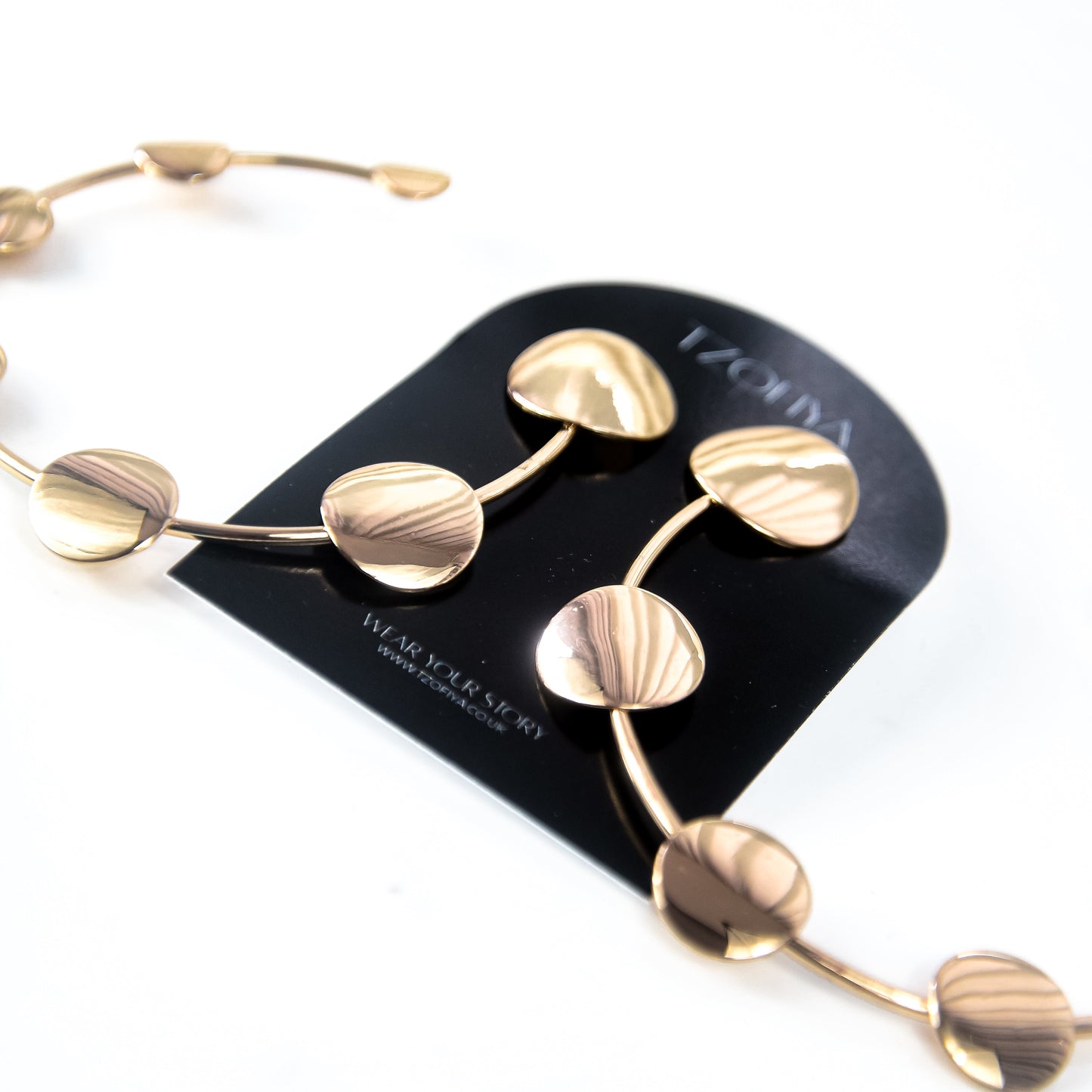 Gold Earrings on a black card with 'Tzofiya" branding on a white background