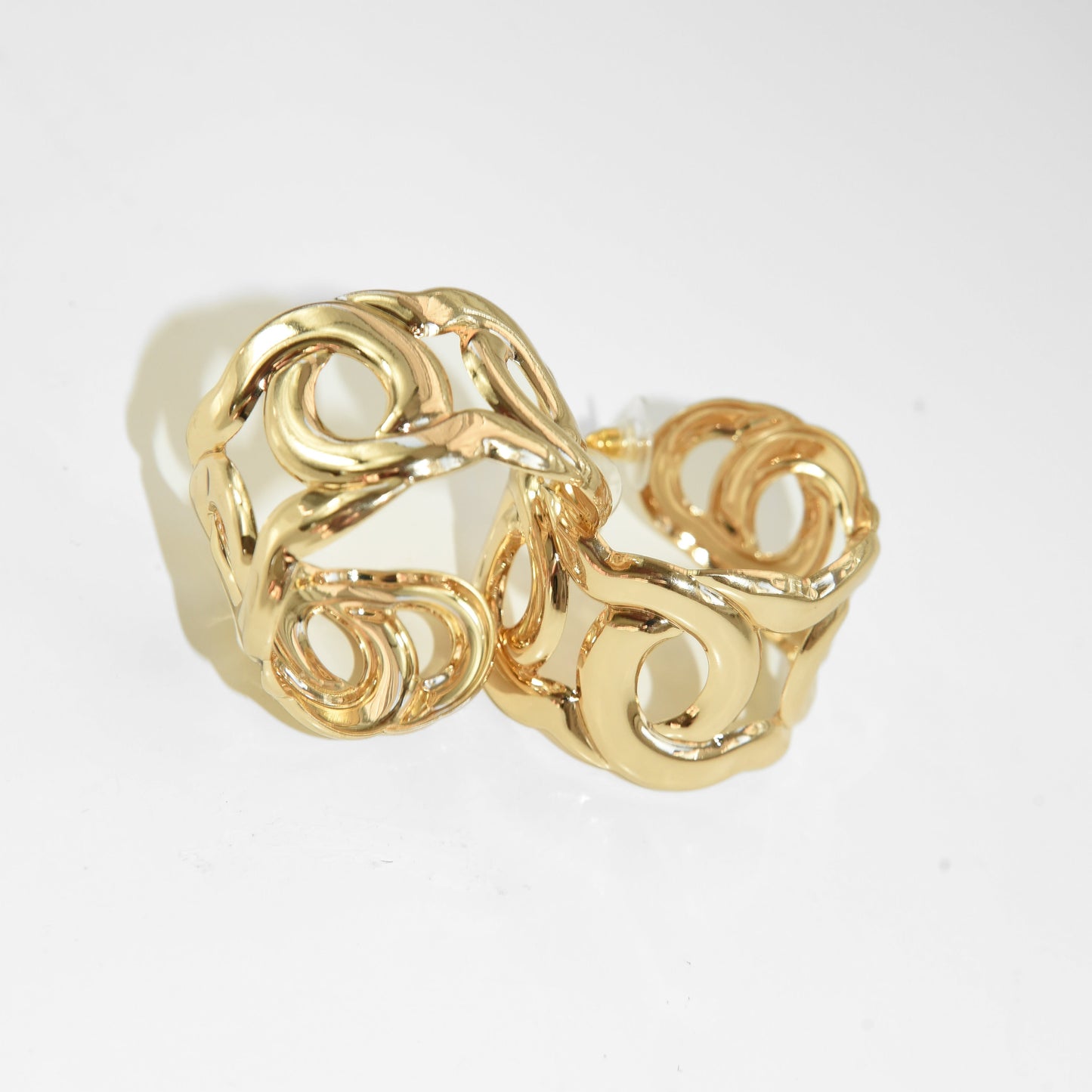 Gold ring with intricate design on a white background