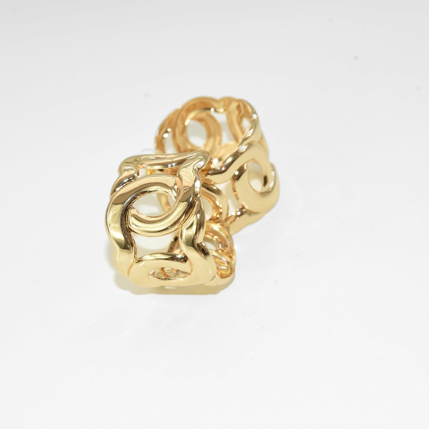 Gold ring with intricate design on a white background