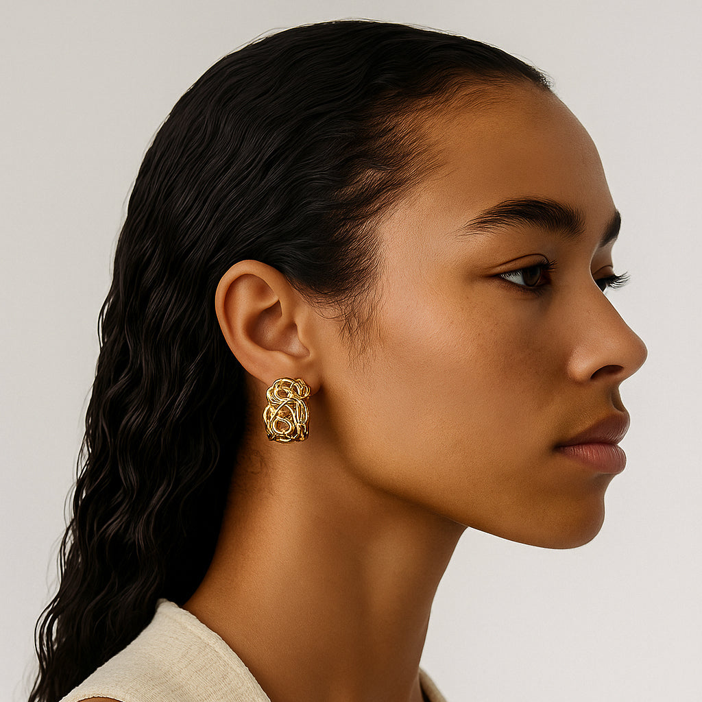 Woman wearing a gold earring against a neutral background