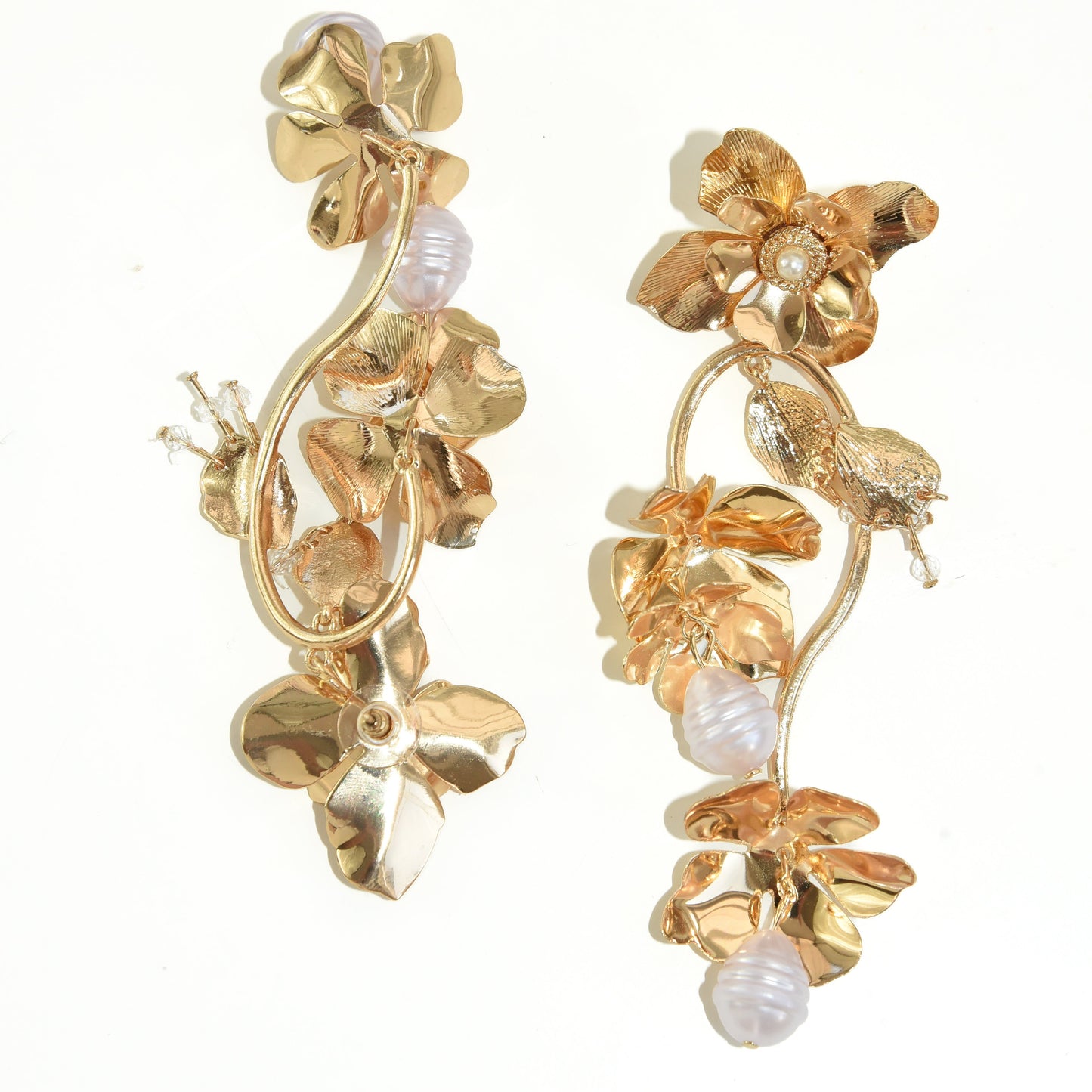 Gold floral earrings with pearl accents on a white background