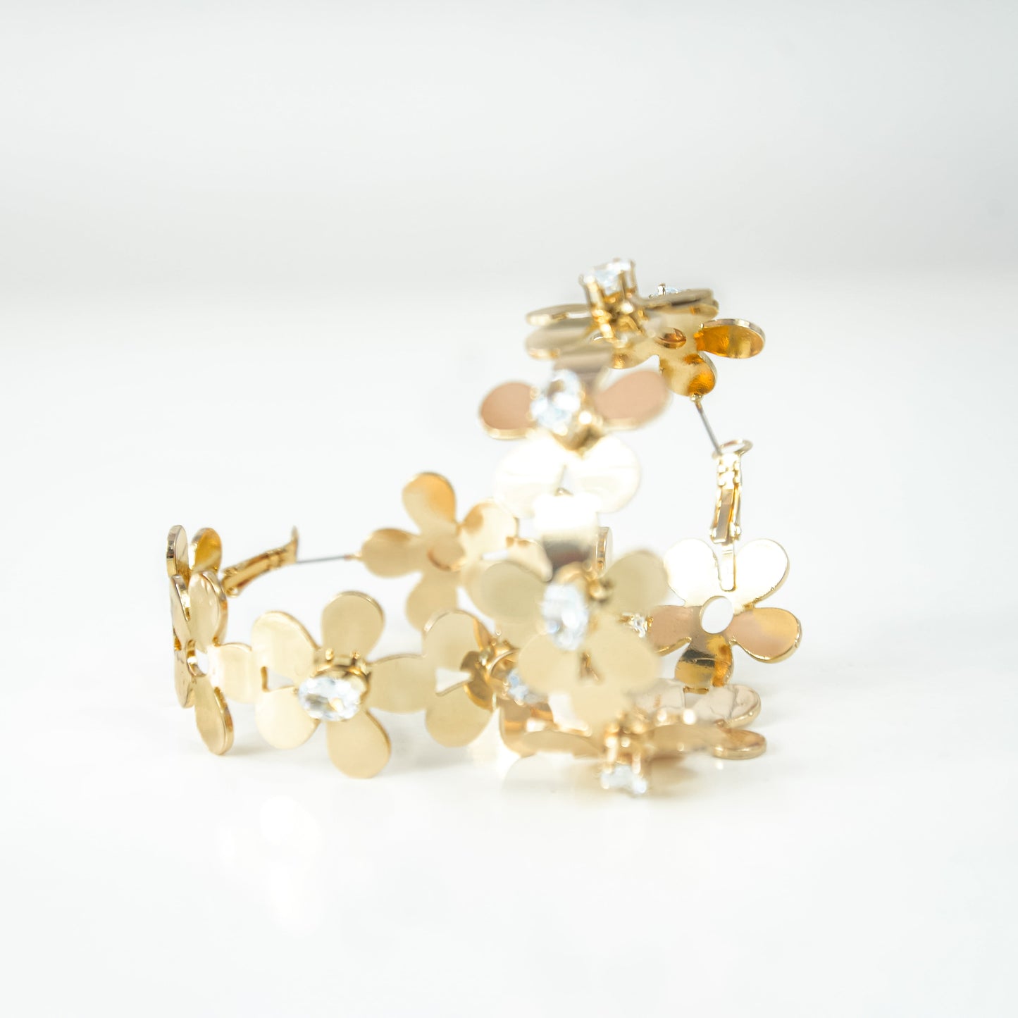 Gold bracelet with floral design on a white background