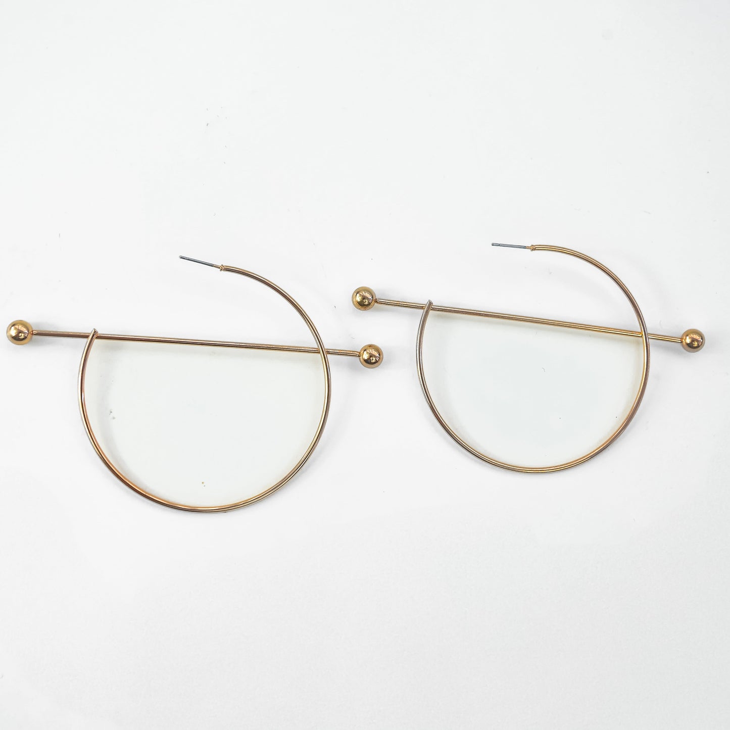 Gold circular earrings on a white background