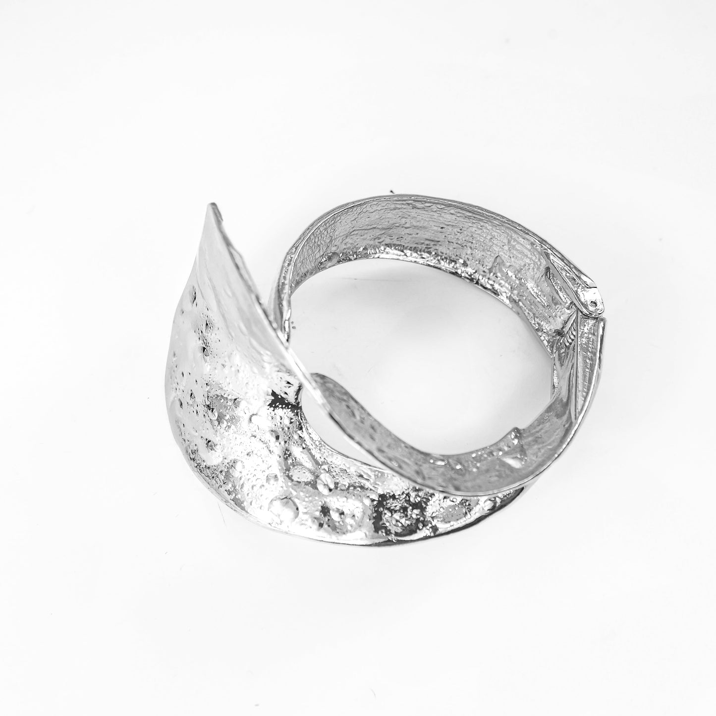 Silver bracelet with a textured band on a white background