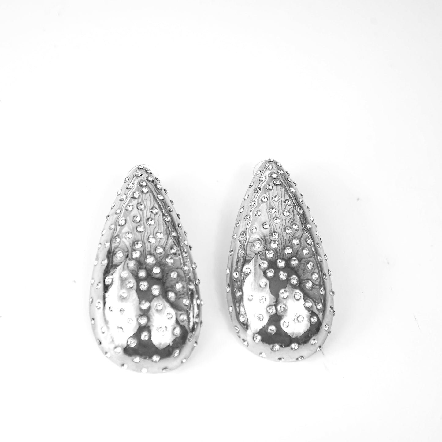 Pair of teardrop-shaped silver earrings with a textured surface on a white background