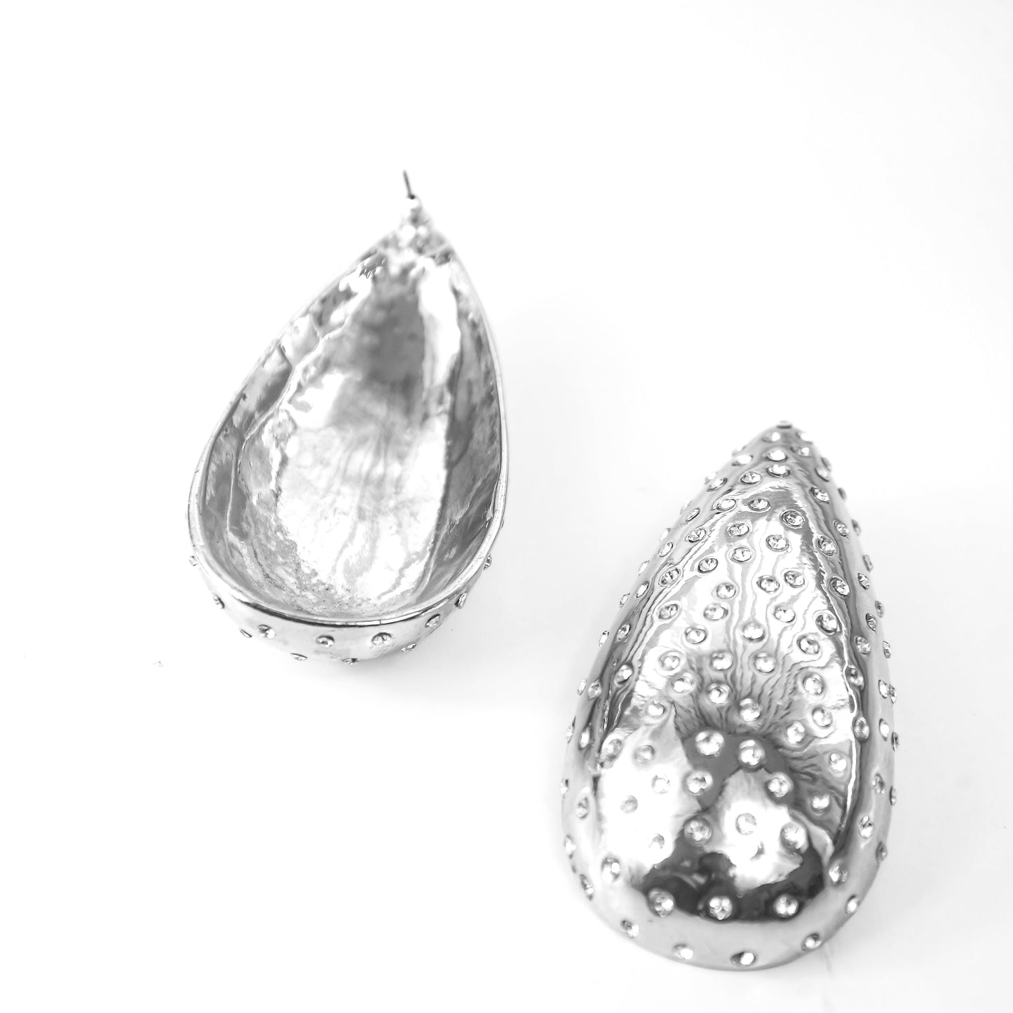 Teardrop-shaped silver earrings on a white background