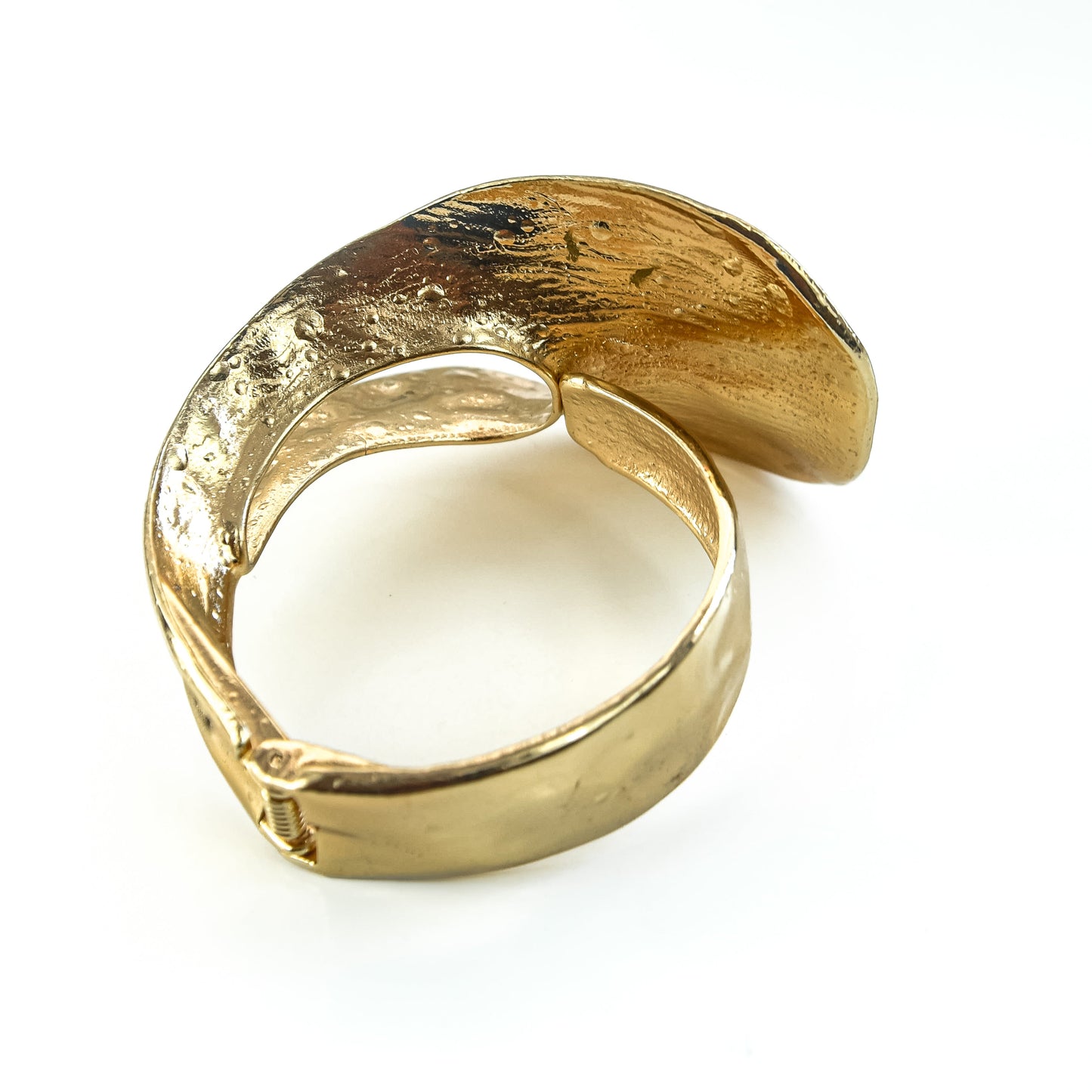 Gold ring with a textured surface on a white background