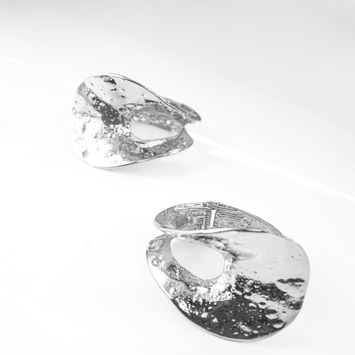 Pair of silver bracelets on a white background