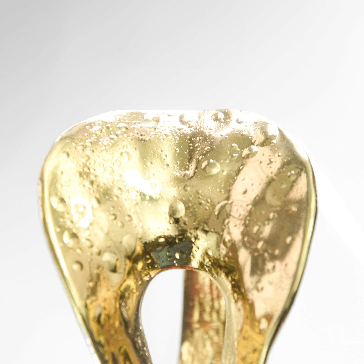 Gold Braclets on a light gray background
