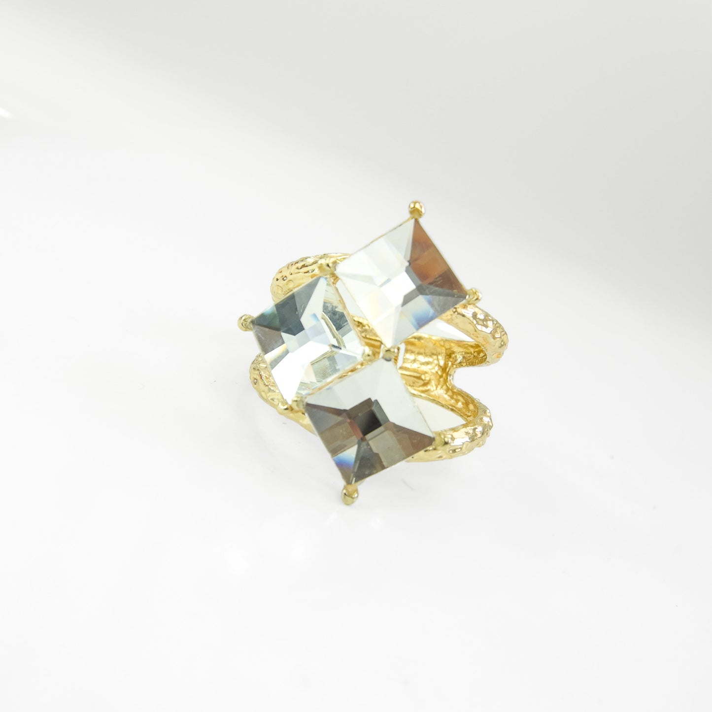 Gold bangle with clear gemstones on a light background