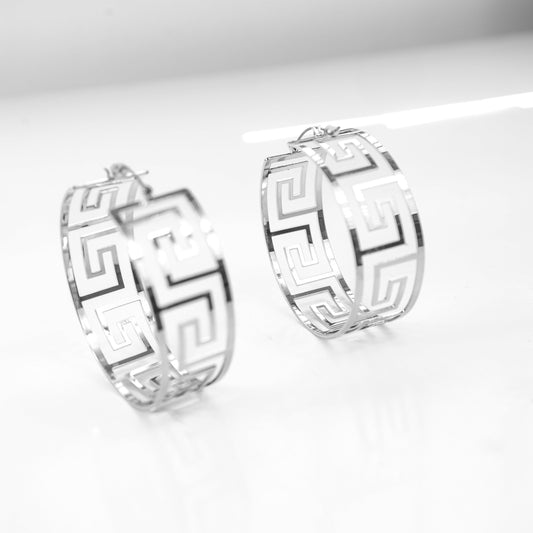 Pair of silver hoop earrings with geometric design on a white background