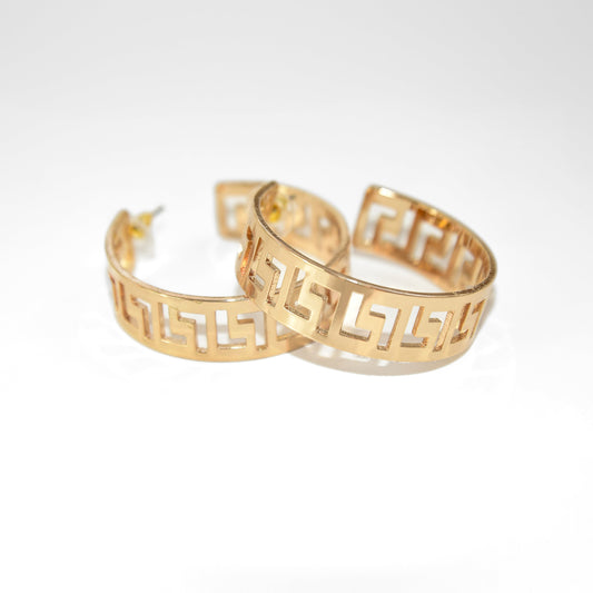 Gold hoop earrings with a geometric pattern on a white background