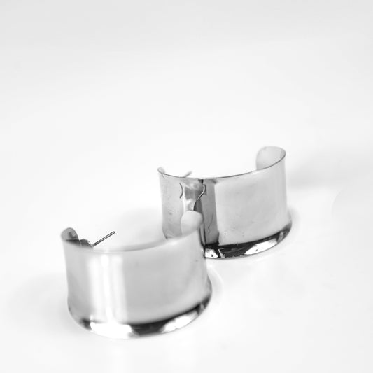Two silver cuffs earrings on a white background