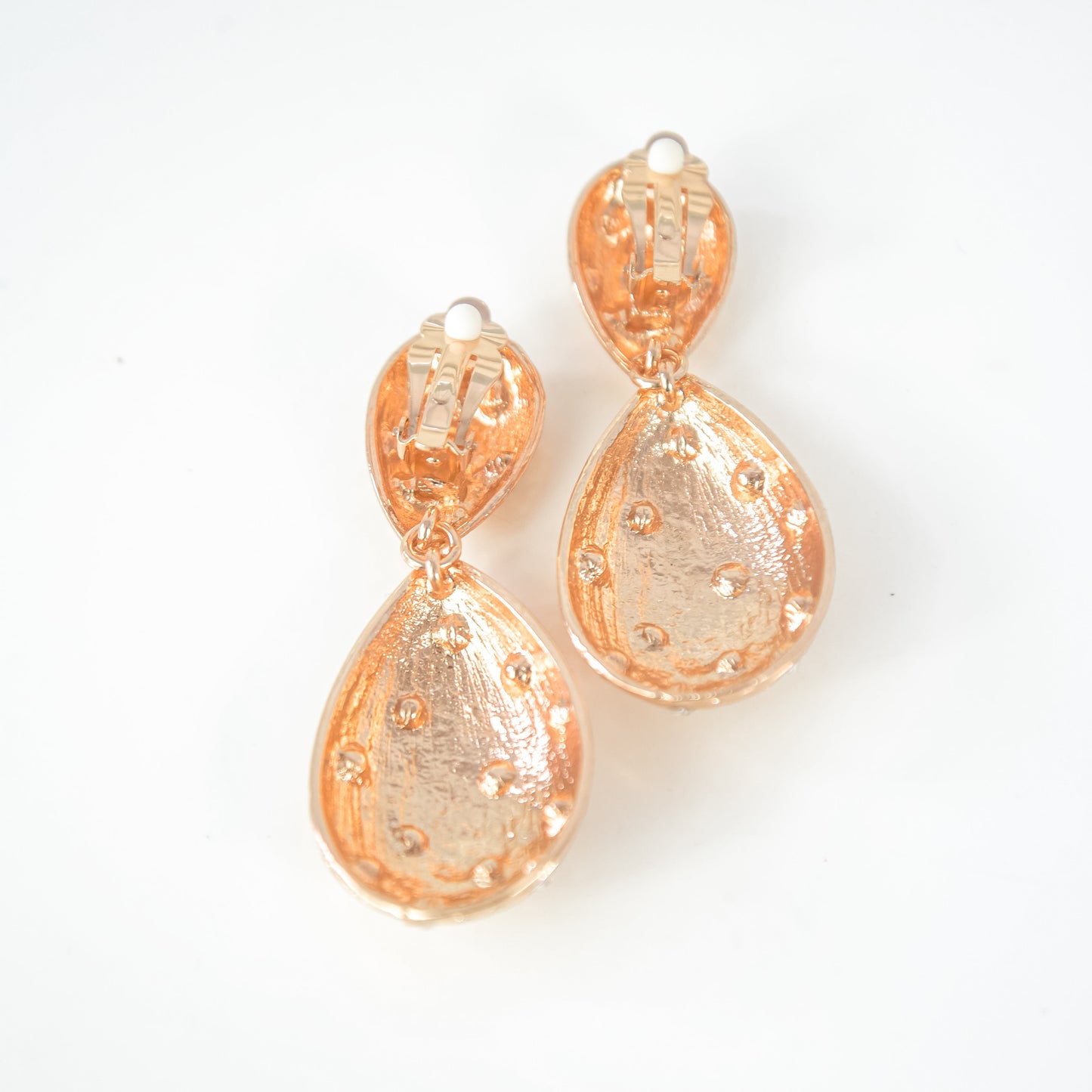 Pair of gold teardrop earrings on a white background
