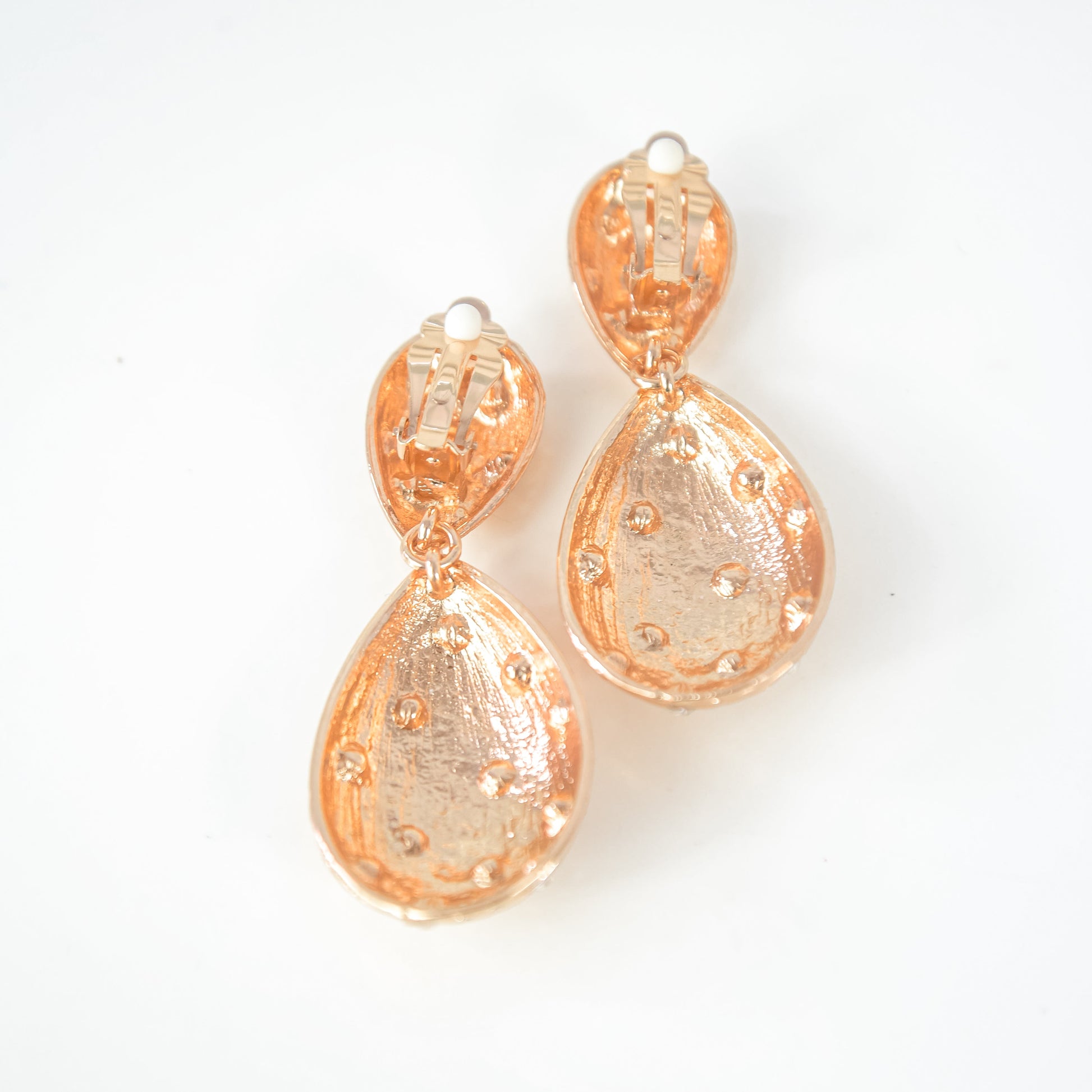 Pair of gold teardrop earrings on a white background