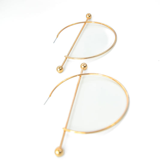 Gold-framed earrings with white stones on a white background