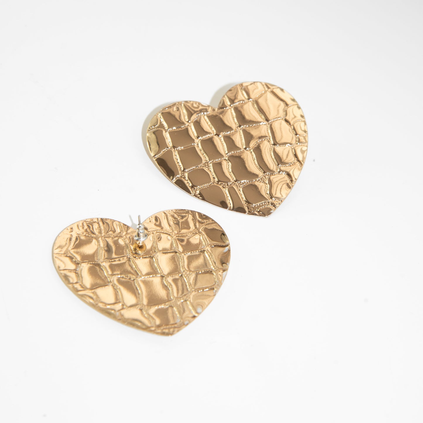 Gold heart-shaped earrings on a white background