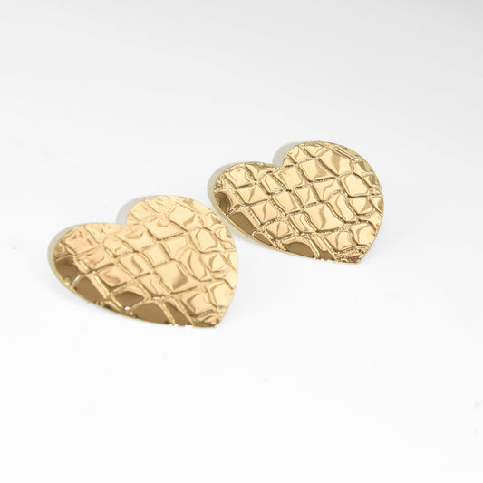 Gold textured heart-shaped earrings on a white background