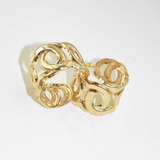 Gold ring with intricate design on a white background