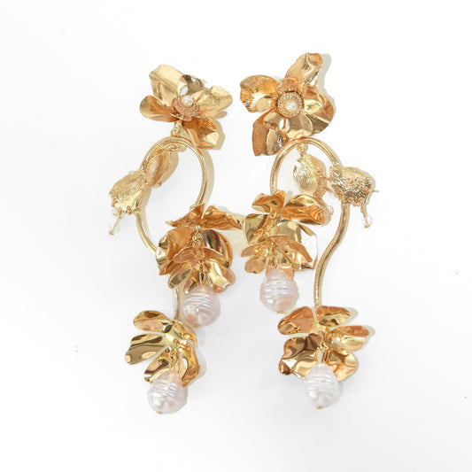 Gold floral earrings with pearl accents on a white background