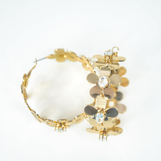 Gold hoop earrings with white stones on a white background