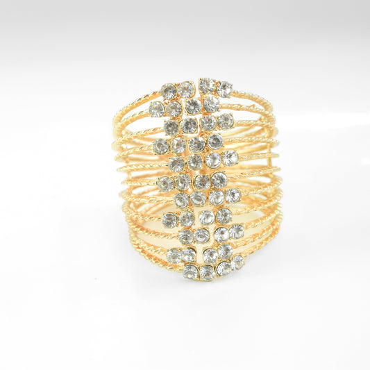 Gold bracelet with embedded crystals on a light gray background