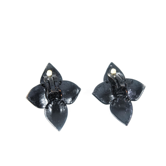 Pair of black flower-shaped earrings on a white background