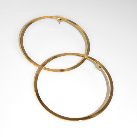 Two gold hoop earrings on a white background