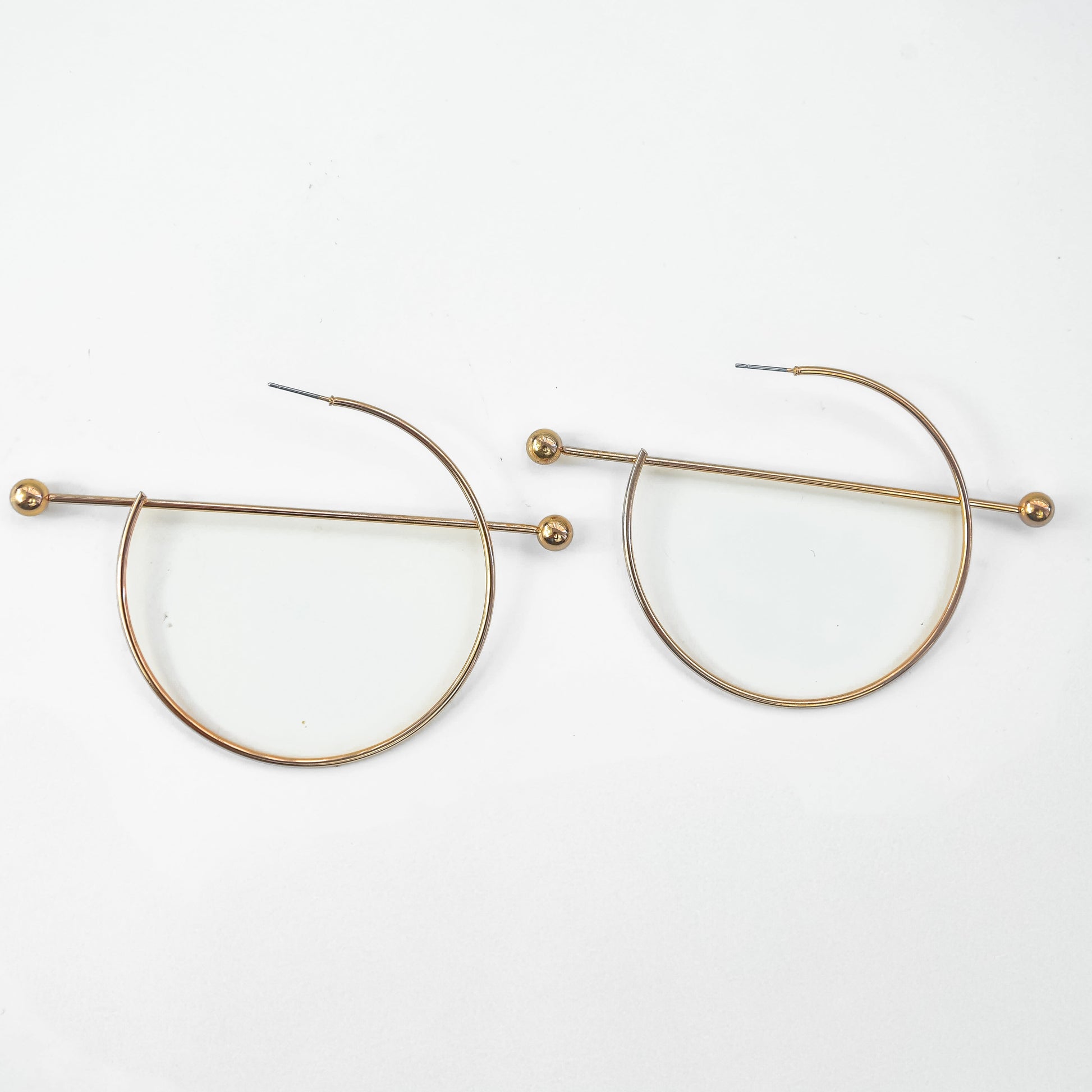 Gold circular earrings on a white background