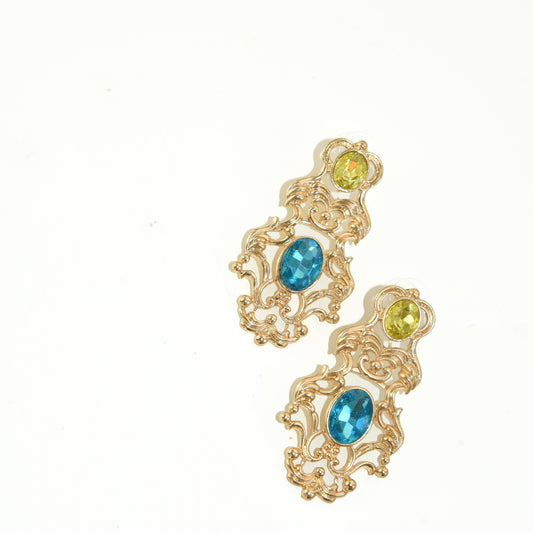 Gold earrings with blue gemstones on a white background