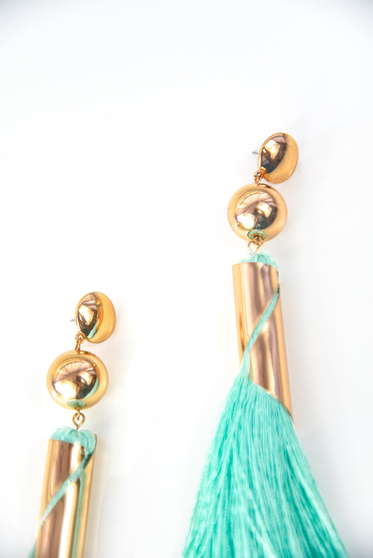 Gold earrings with turquoise tassels on a white background