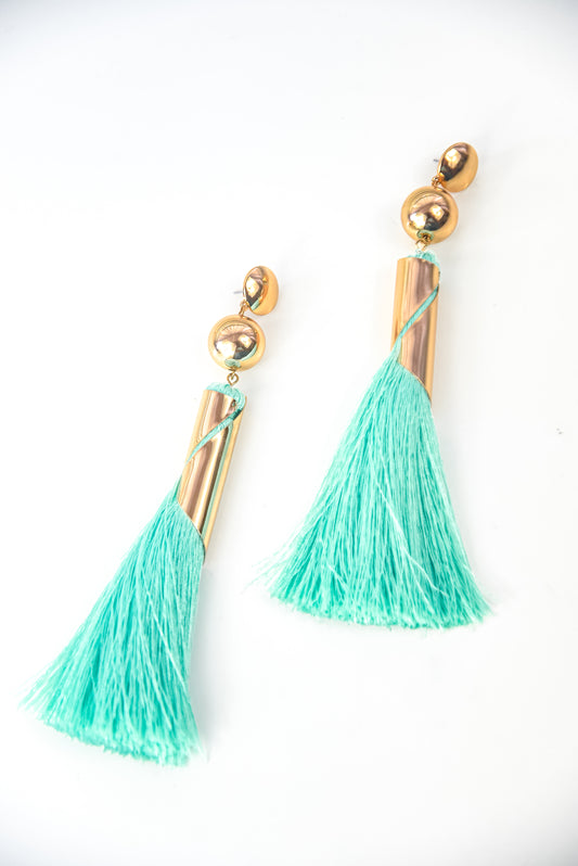 Turquoise tassel earrings with gold accents on a white background